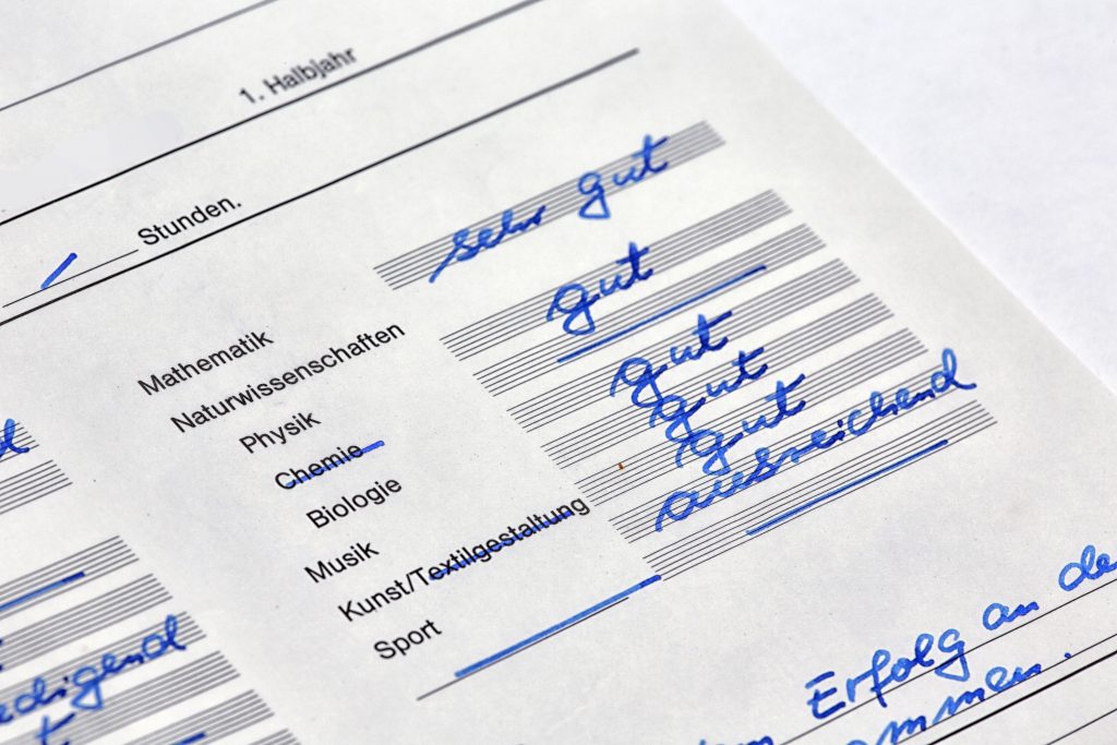 Ausschnitt eines Zeugnisses mit handschriftlich eingetragenen Noten von "sehr gut" bis "ausreichend" in verschiedenen Fächern